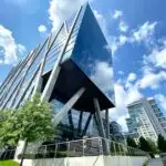 A striking modern office building with glass facade in Reston, VA under a clear blue sky.